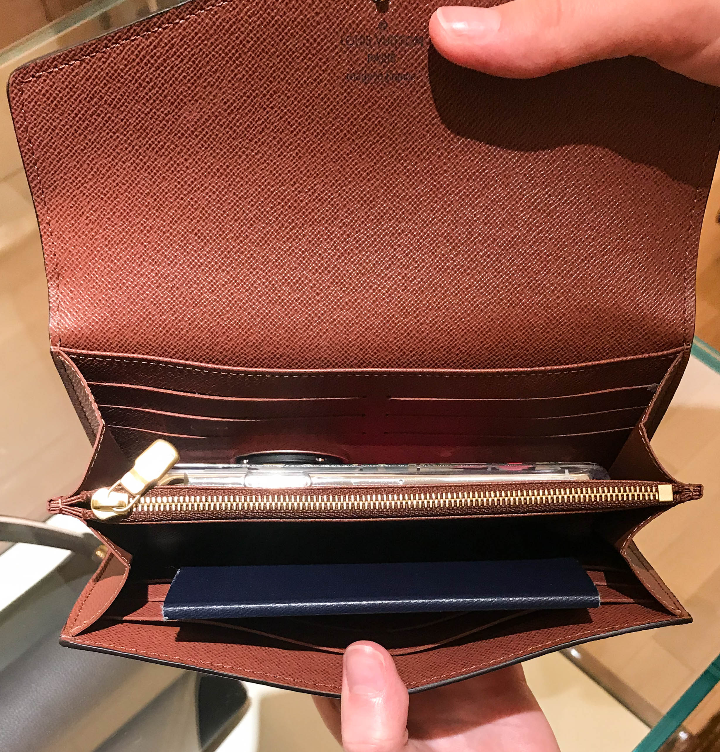 Louis Vuitton Sarah wallet with iPhone and passport inside.