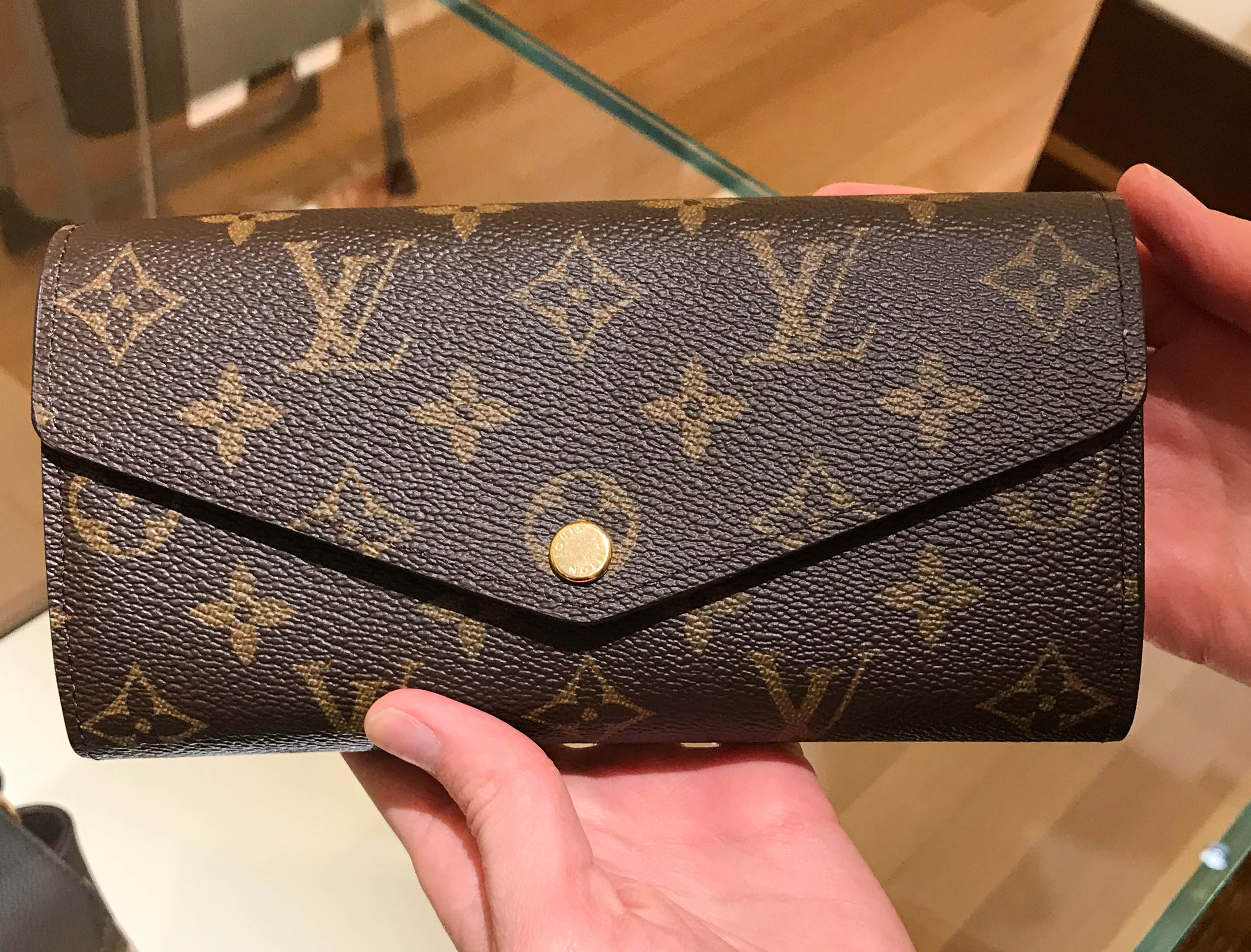 Louis Vuitton Sarah wallet with iPhone and passport inside.